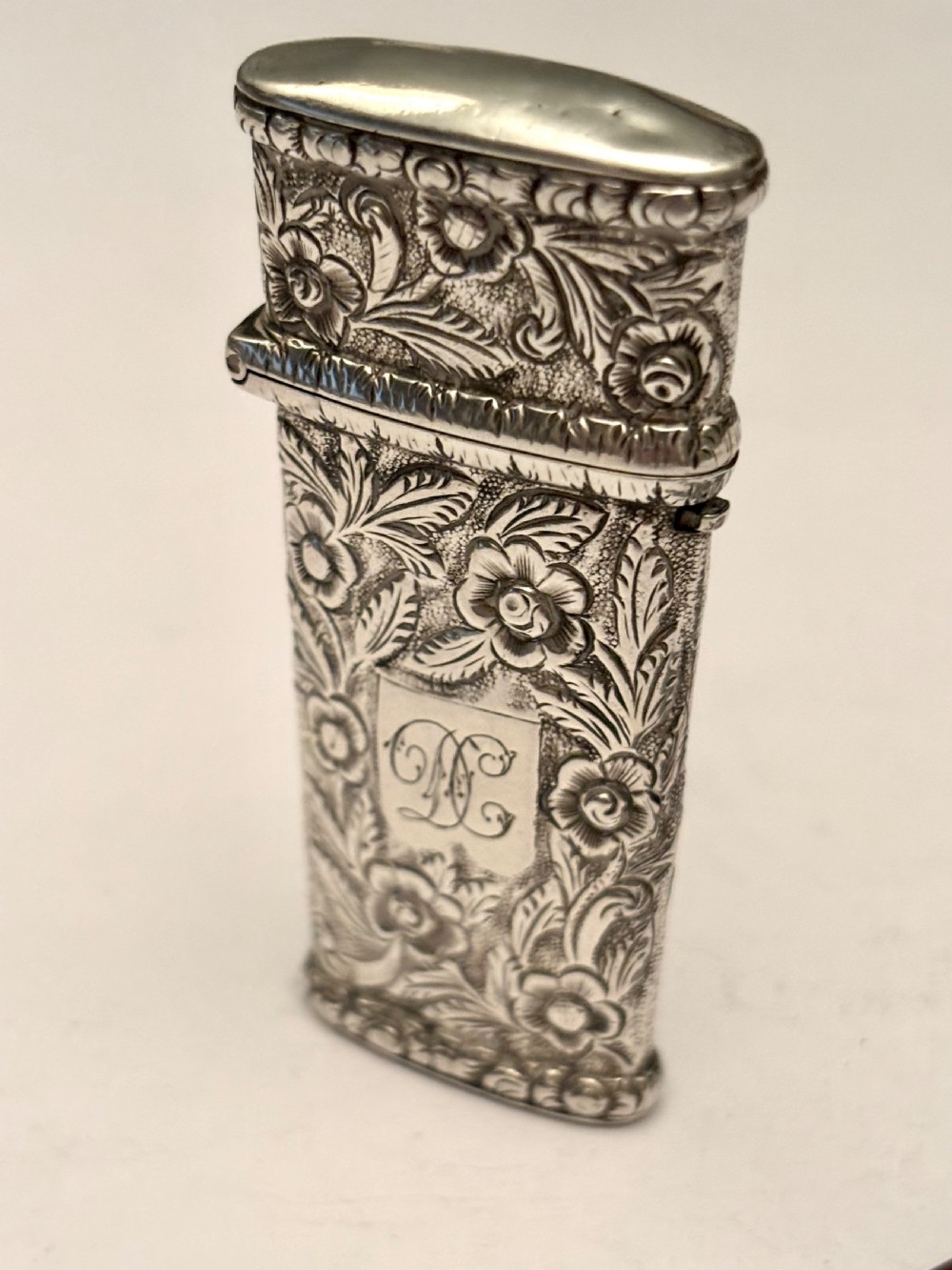 An open William IV sterling silver fleam case with floral chasing, revealing two dark-handled folding blades inside. View X