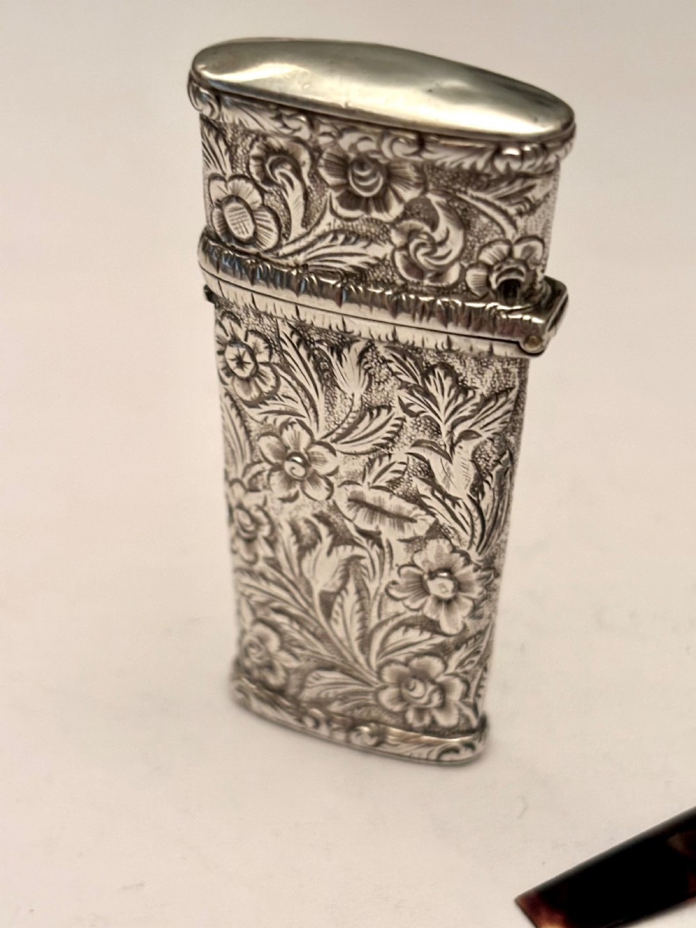 An open William IV sterling silver fleam case with floral chasing, revealing two dark-handled folding blades inside. View XI