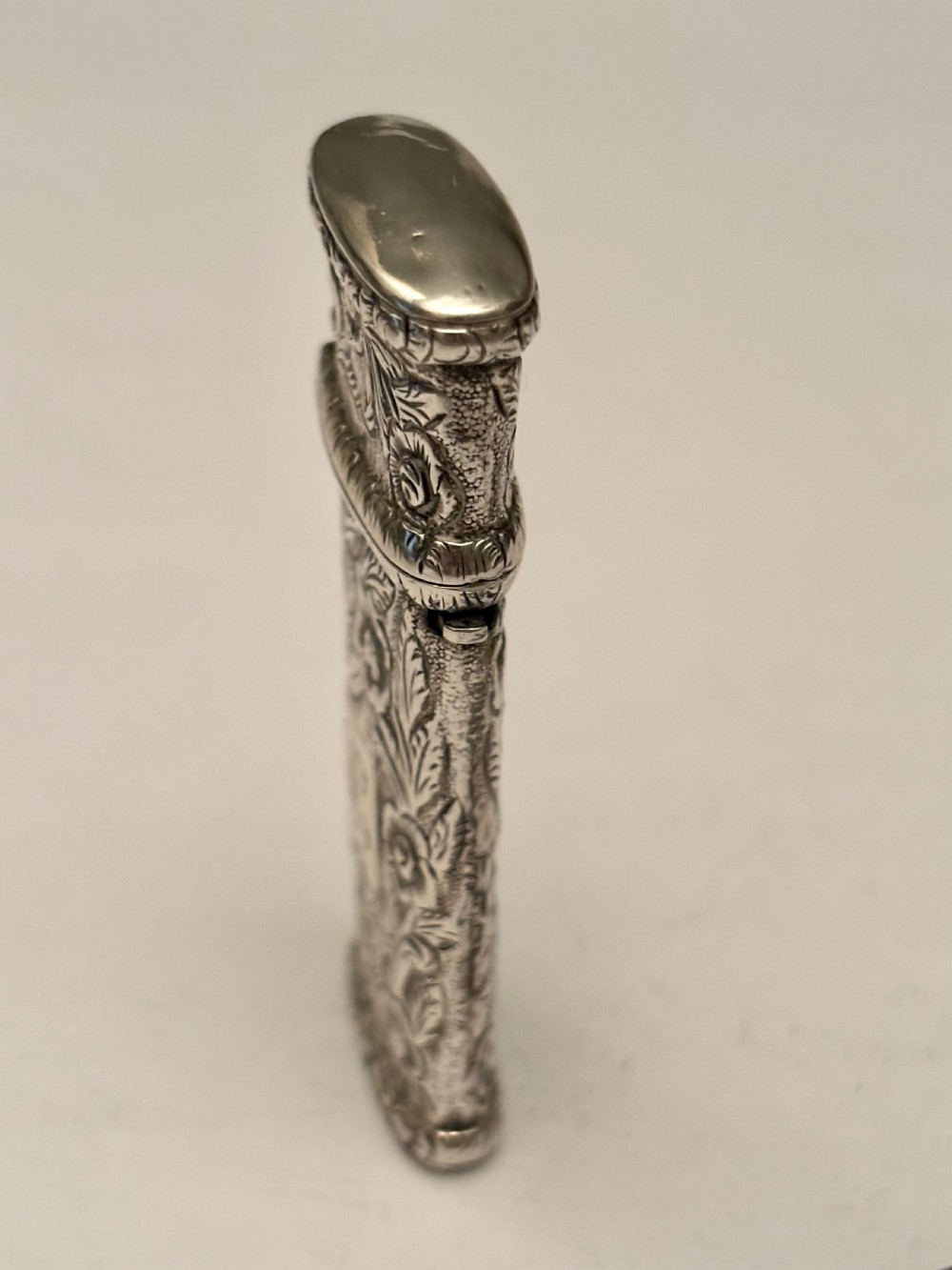 An open William IV sterling silver fleam case with floral chasing, revealing two dark-handled folding blades inside. View XII