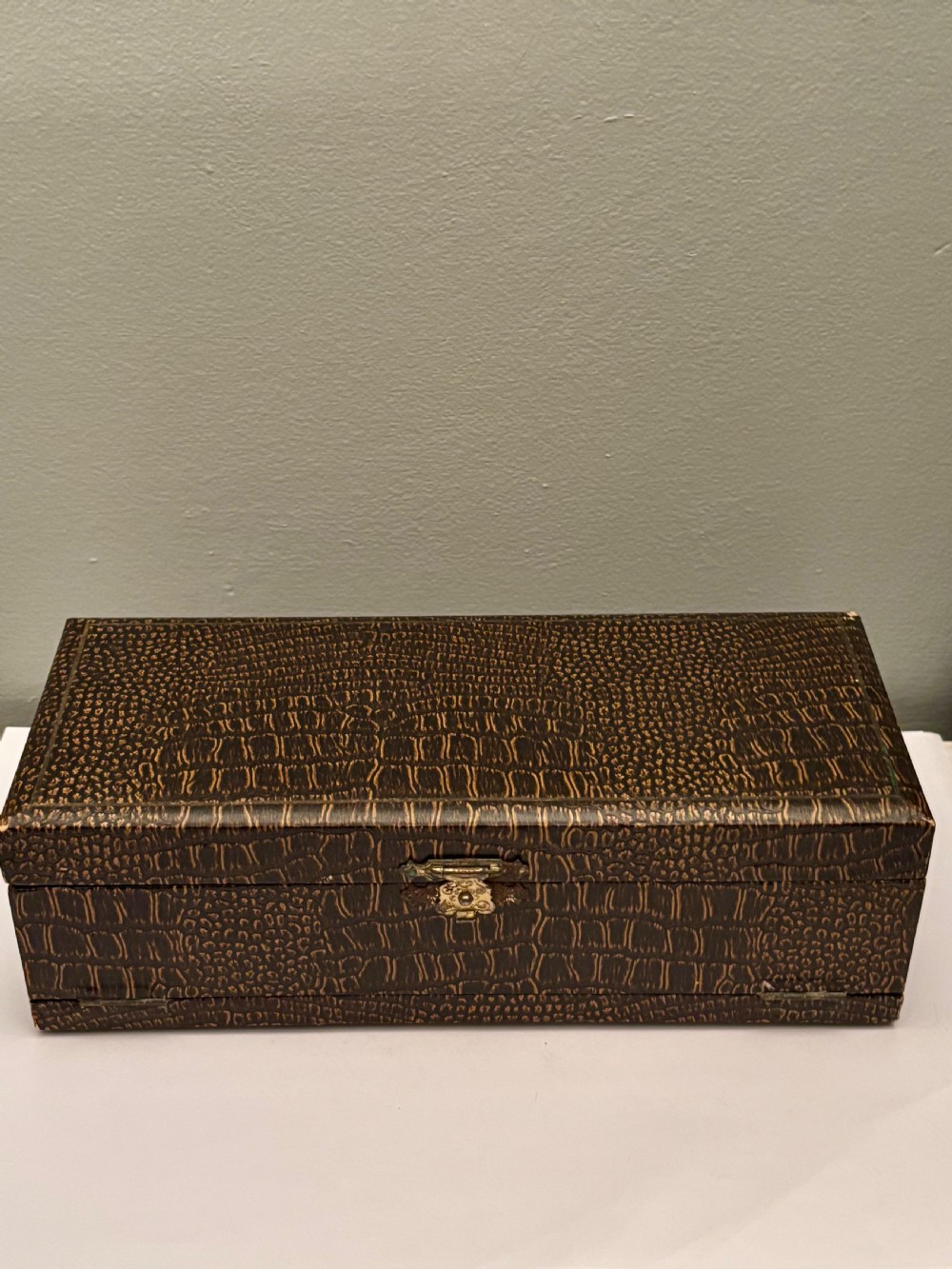 An open fitted presentation box containing two silver gilt candlesticks, a central inkwell, and a dip pen. View V