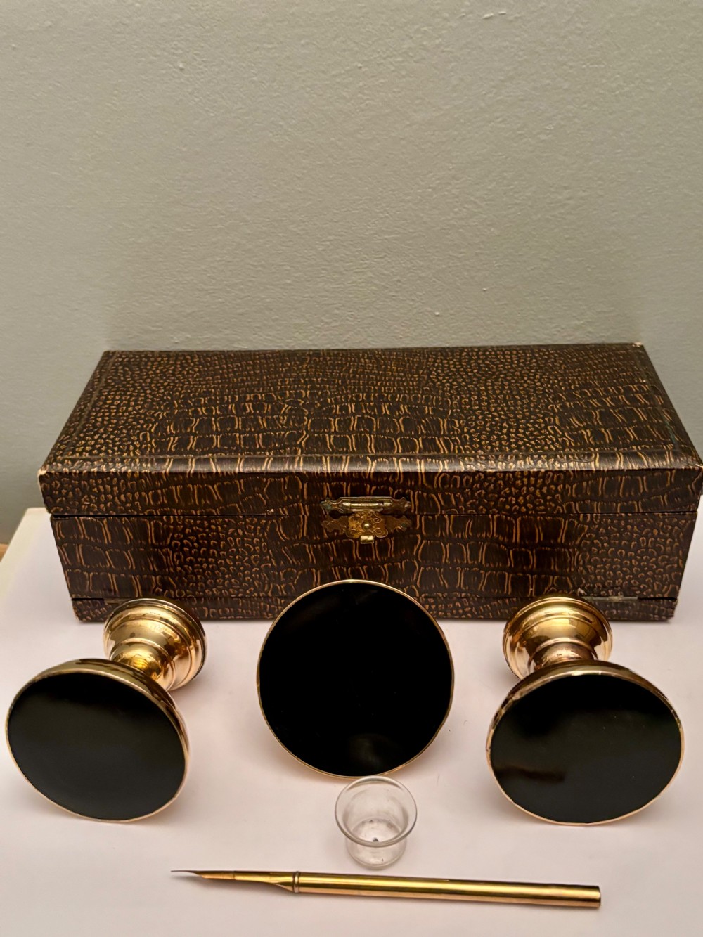 An open fitted presentation box containing two silver gilt candlesticks, a central inkwell, and a dip pen. View VII