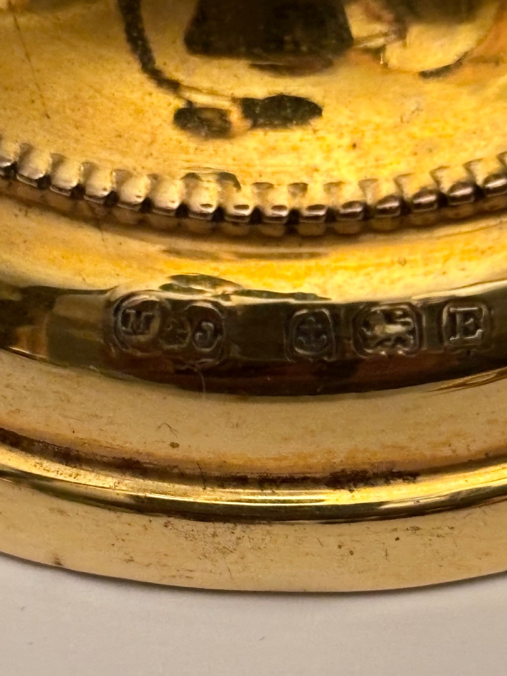 An open fitted presentation box containing two silver gilt candlesticks, a central inkwell, and a dip pen. View X