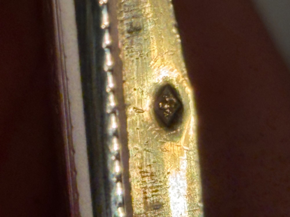A small rectangular 19th-century French 950 silver gilt snuff box decorated with dense chased scrolling patterns and stippled texture. View XI