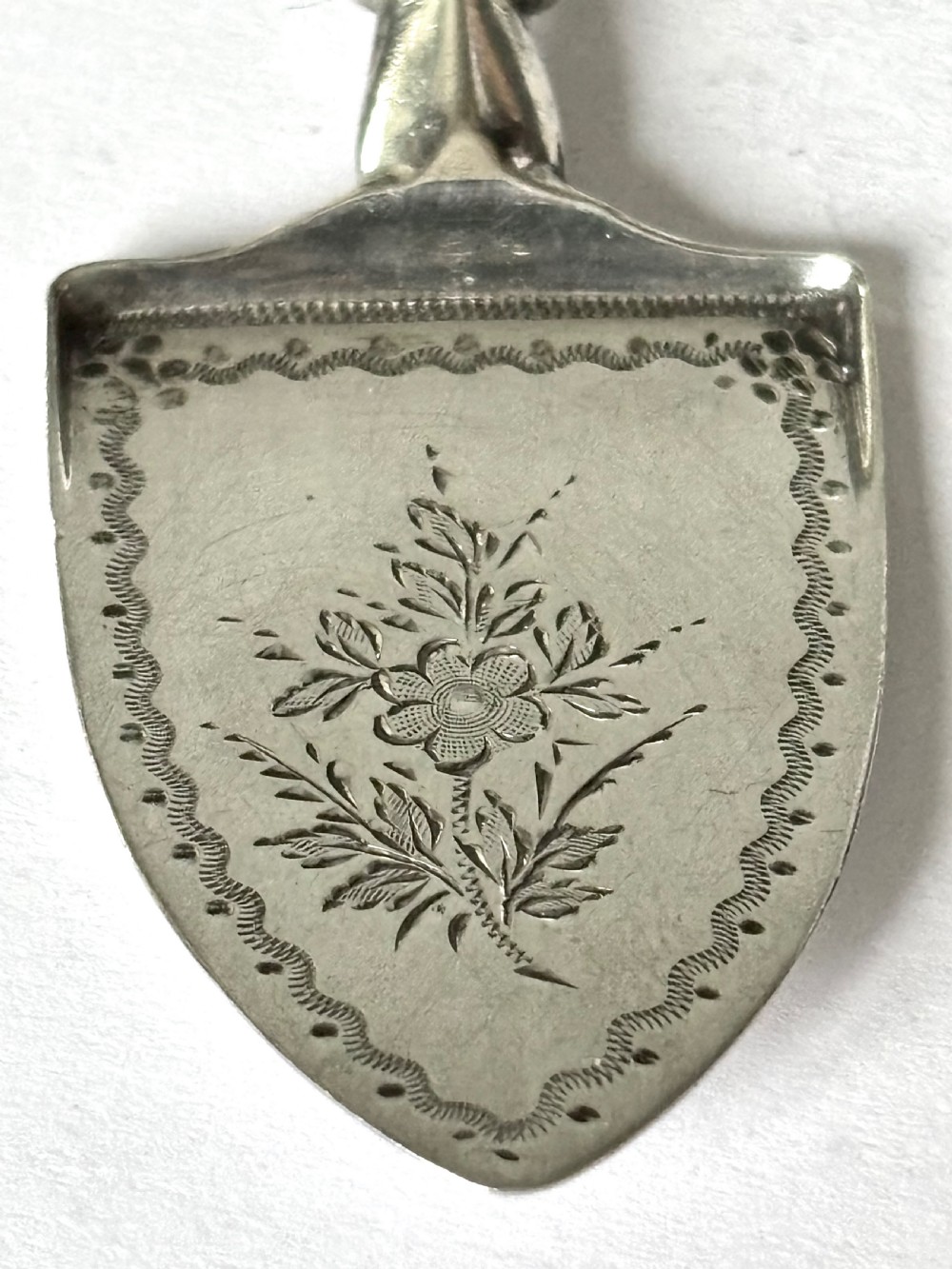 A Victorian sterling silver butter spade featuring an engraved floral blade and a smooth mother-of-pearl handle. View II