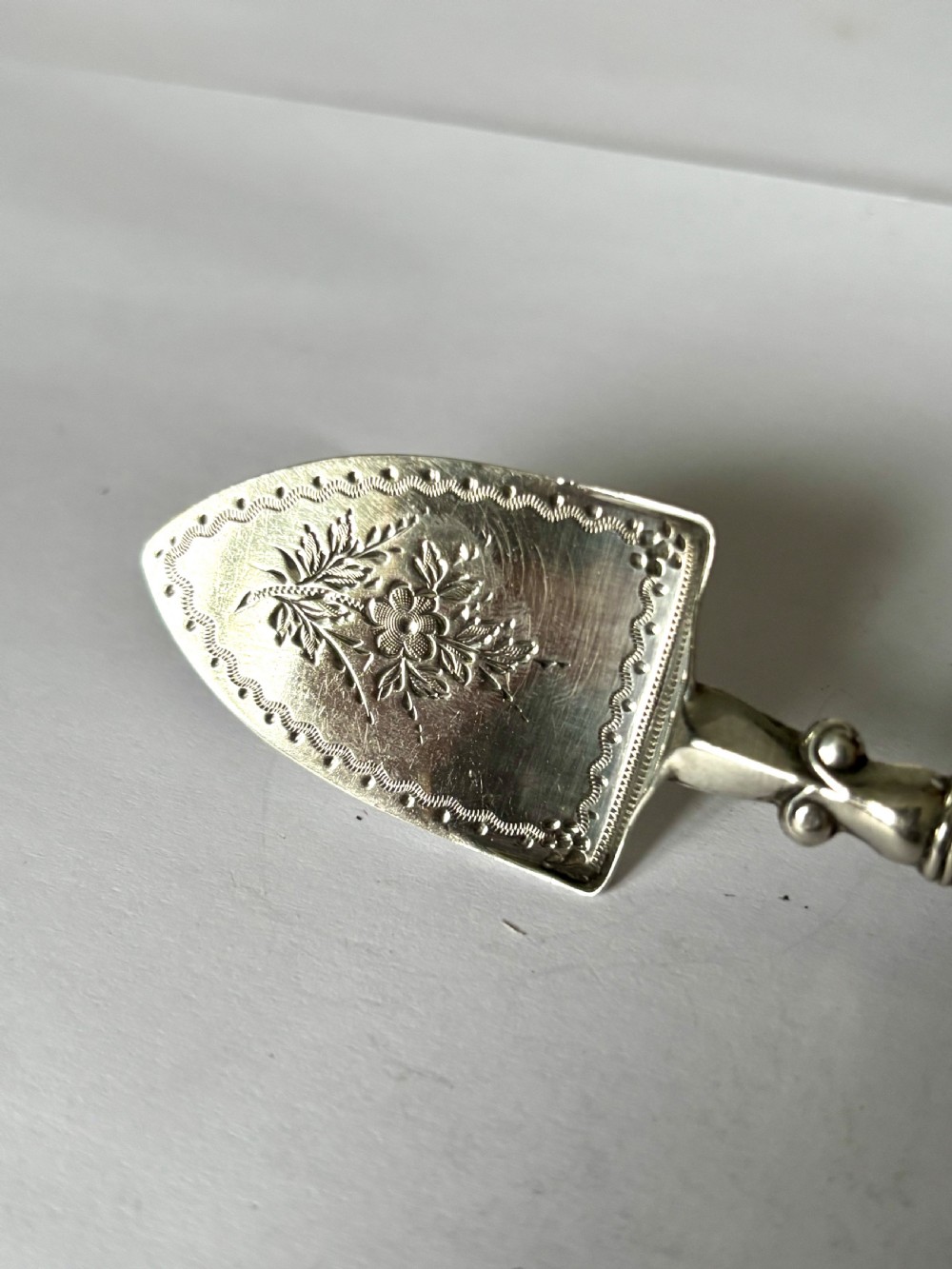 A Victorian sterling silver butter spade featuring an engraved floral blade and a smooth mother-of-pearl handle. View III