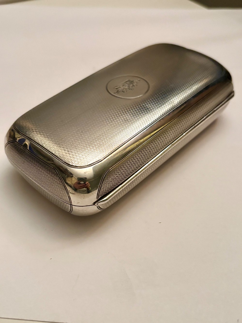 A rectangular Victorian sterling silver box featuring fine engine-turned geometric engraving and a central engraved coronet crest. View II