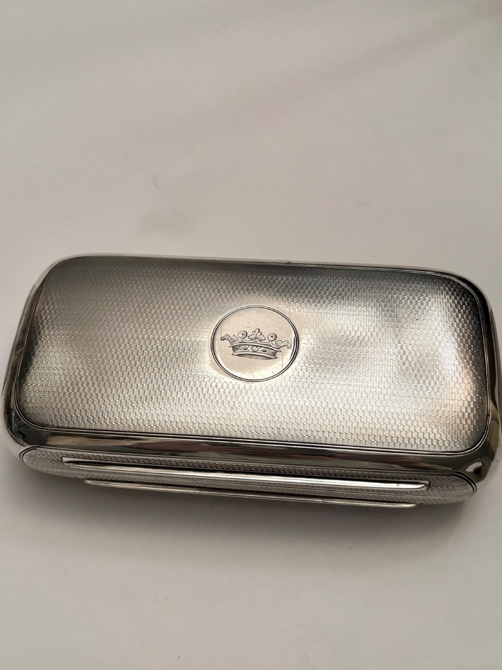 A rectangular Victorian sterling silver box featuring fine engine-turned geometric engraving and a central engraved coronet crest. View IV