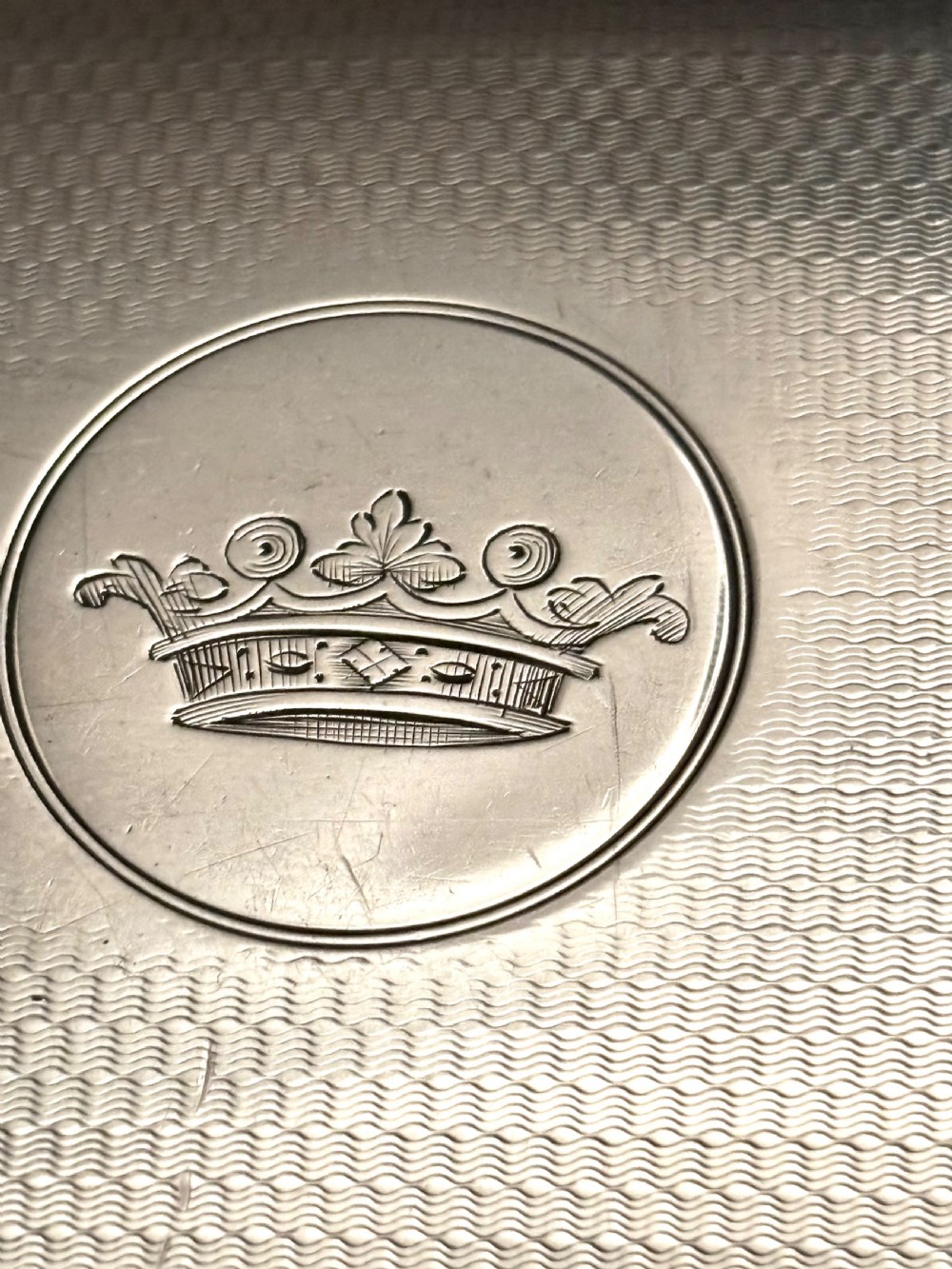 A rectangular Victorian sterling silver box featuring fine engine-turned geometric engraving and a central engraved coronet crest. View VI