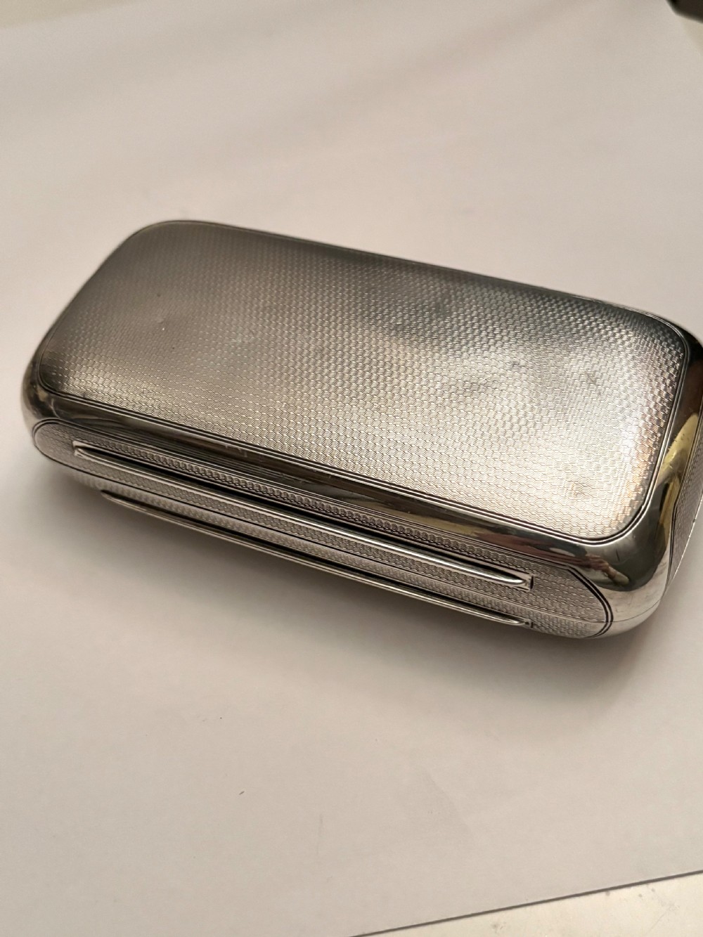 A rectangular Victorian sterling silver box featuring fine engine-turned geometric engraving and a central engraved coronet crest. View VII