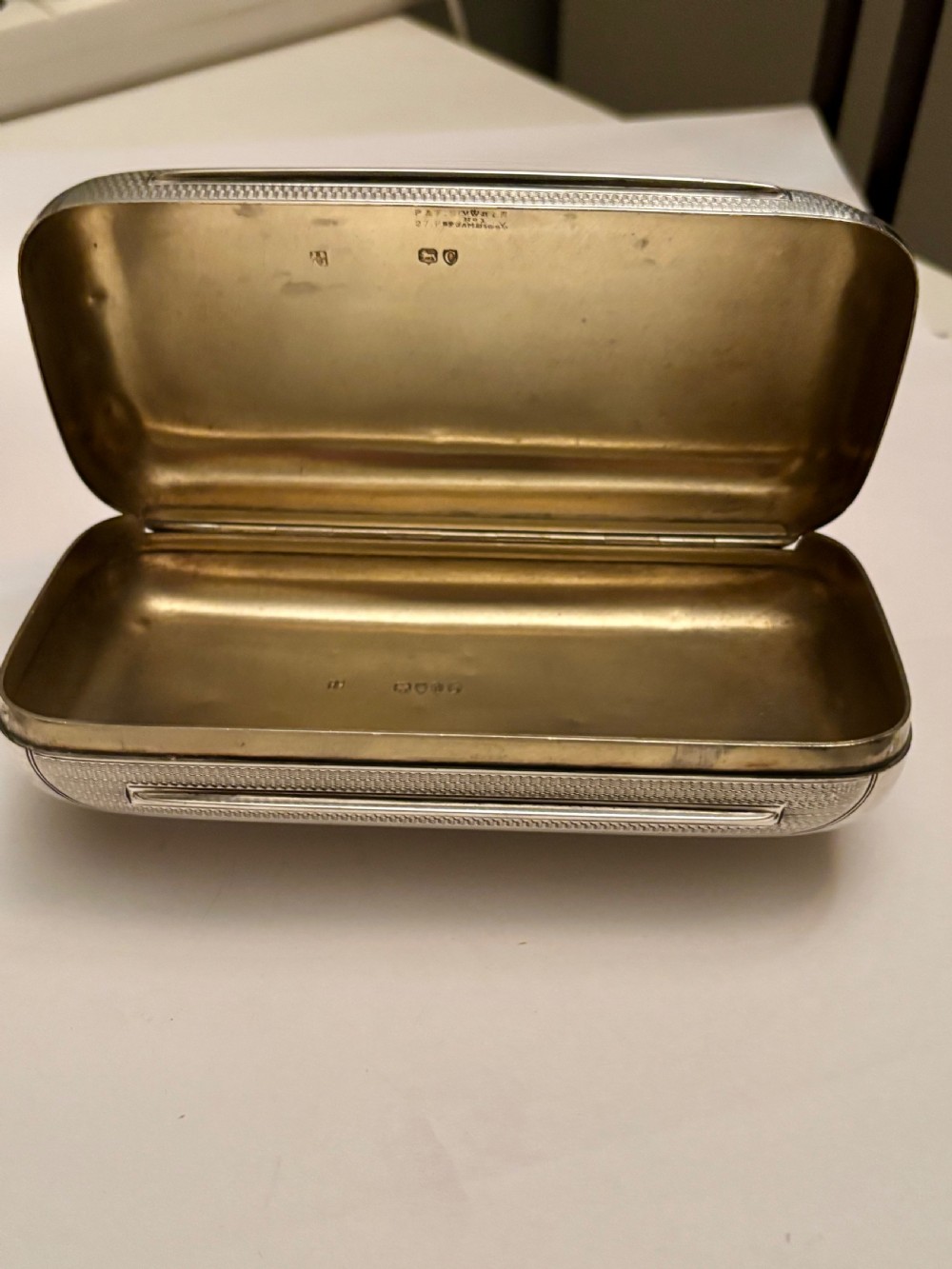 A rectangular Victorian sterling silver box featuring fine engine-turned geometric engraving and a central engraved coronet crest. View XII