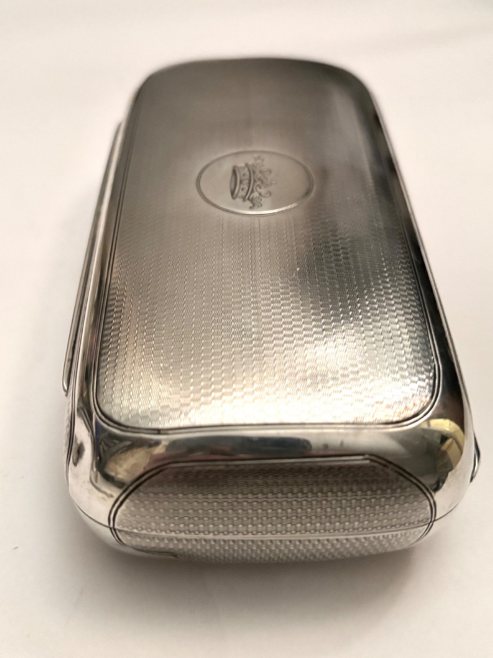 A rectangular Victorian sterling silver box featuring fine engine-turned geometric engraving and a central engraved coronet crest. View XIV
