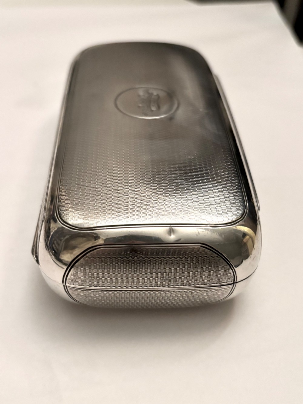 A rectangular Victorian sterling silver box featuring fine engine-turned geometric engraving and a central engraved coronet crest. View XV