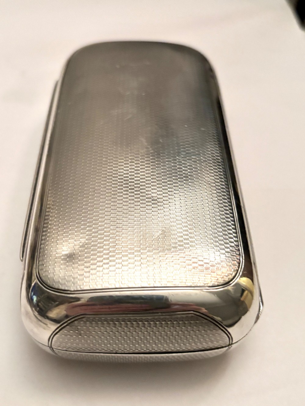 A rectangular Victorian sterling silver box featuring fine engine-turned geometric engraving and a central engraved coronet crest. View XVI