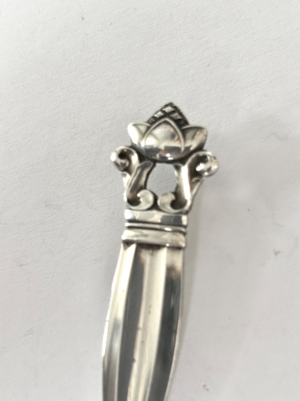 A sterling silver tea caddy spoon featuring a rounded bowl and an acorn motif finial. View IV