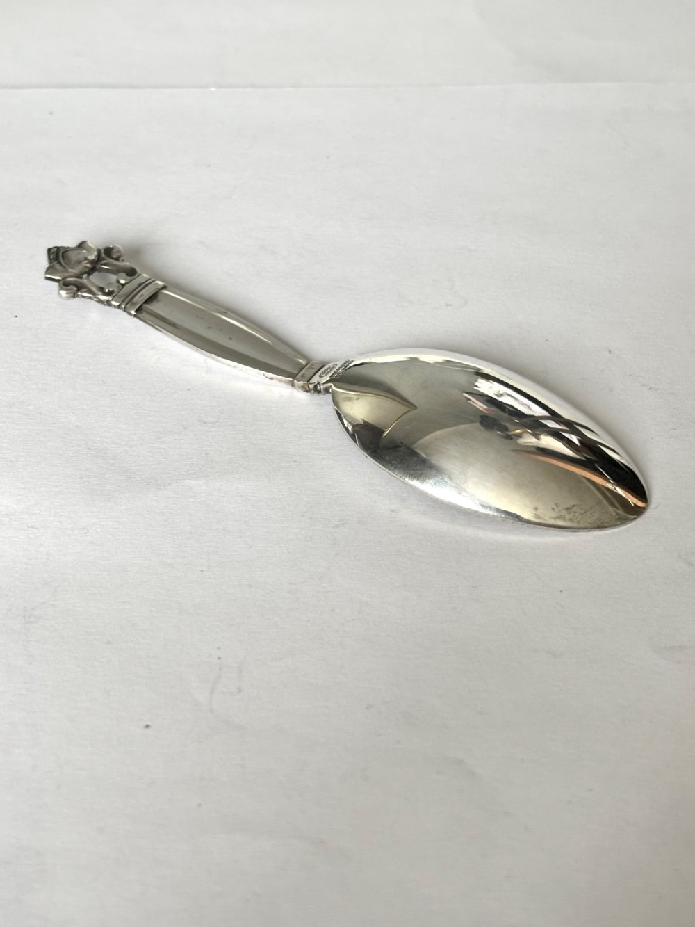 A sterling silver tea caddy spoon featuring a rounded bowl and an acorn motif finial. View VI