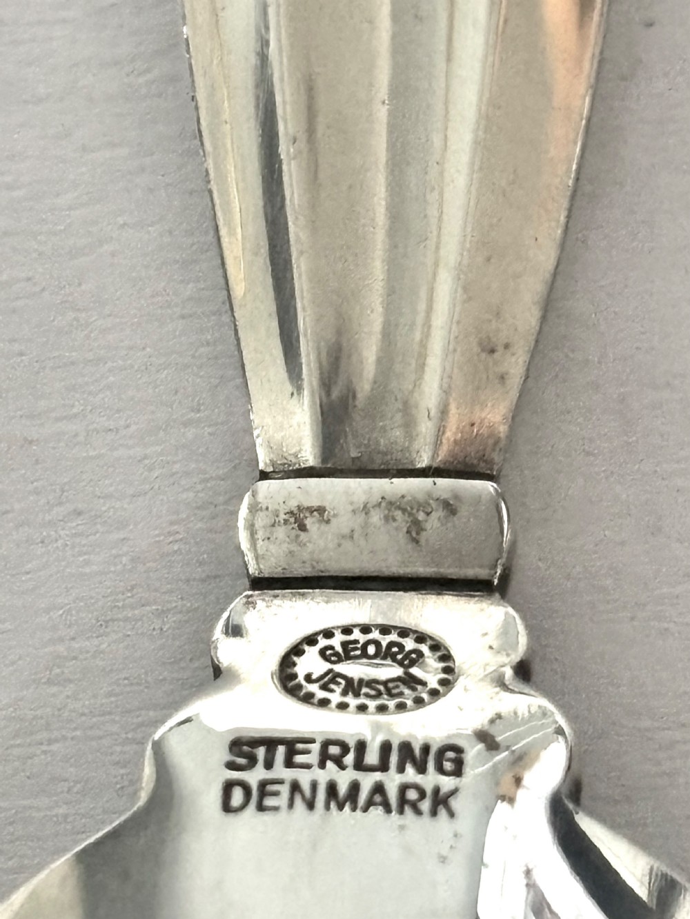 A sterling silver tea caddy spoon featuring a rounded bowl and an acorn motif finial. View VII
