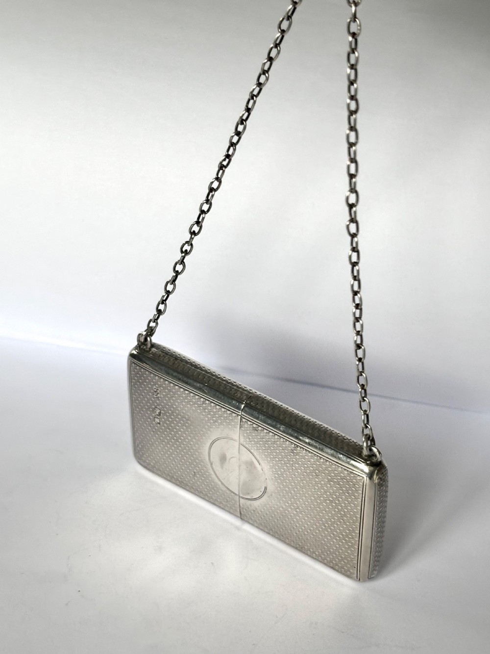 A Victorian sterling silver purse with engine-turned geometric engraving, shown open with a blue silk concertina lining beside a detachable silver case. View III