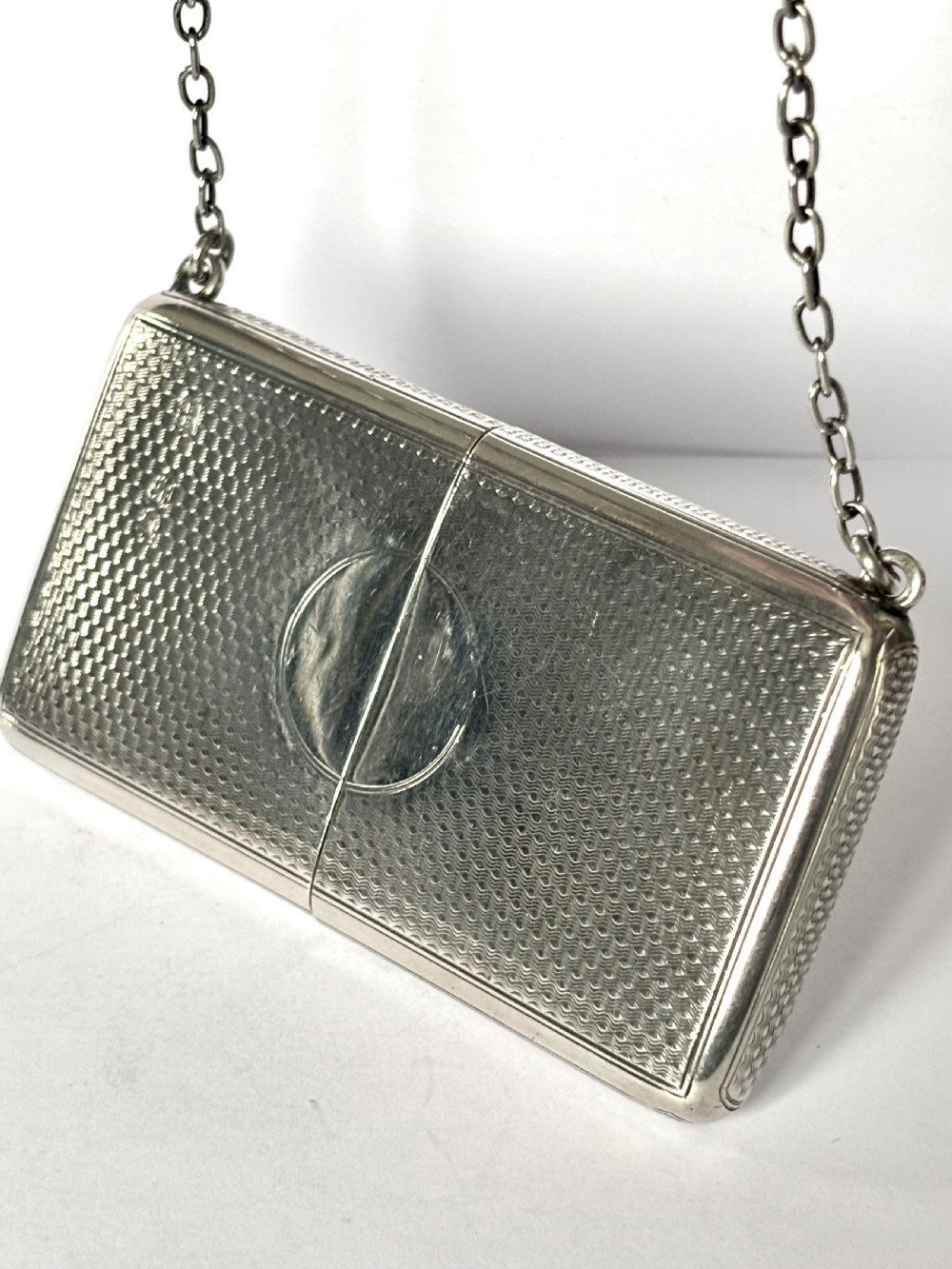 A Victorian sterling silver purse with engine-turned geometric engraving, shown open with a blue silk concertina lining beside a detachable silver case. View IV