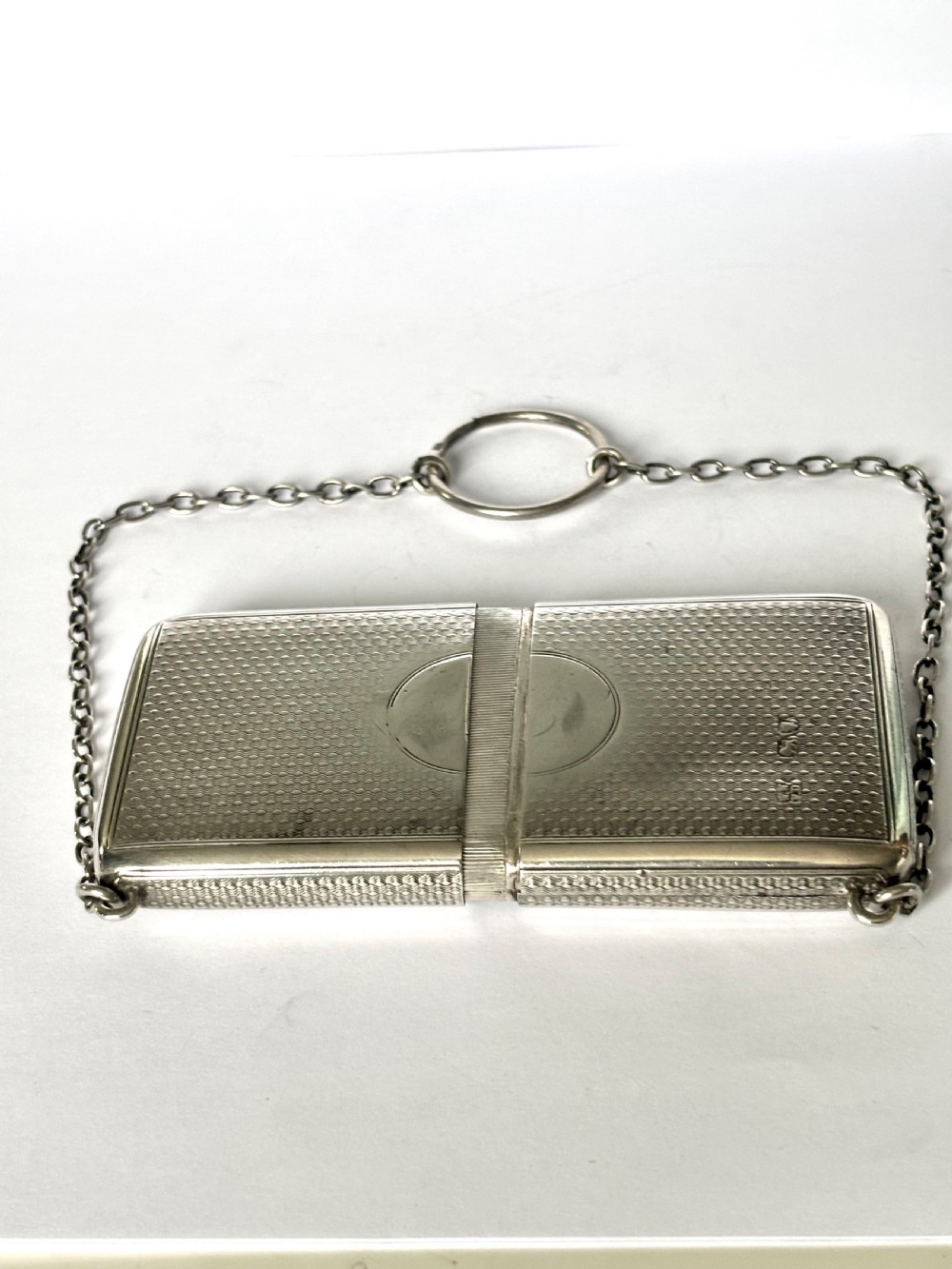 A Victorian sterling silver purse with engine-turned geometric engraving, shown open with a blue silk concertina lining beside a detachable silver case. View XI