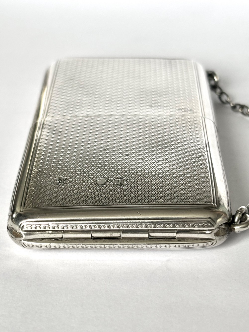 A Victorian sterling silver purse with engine-turned geometric engraving, shown open with a blue silk concertina lining beside a detachable silver case. View XII