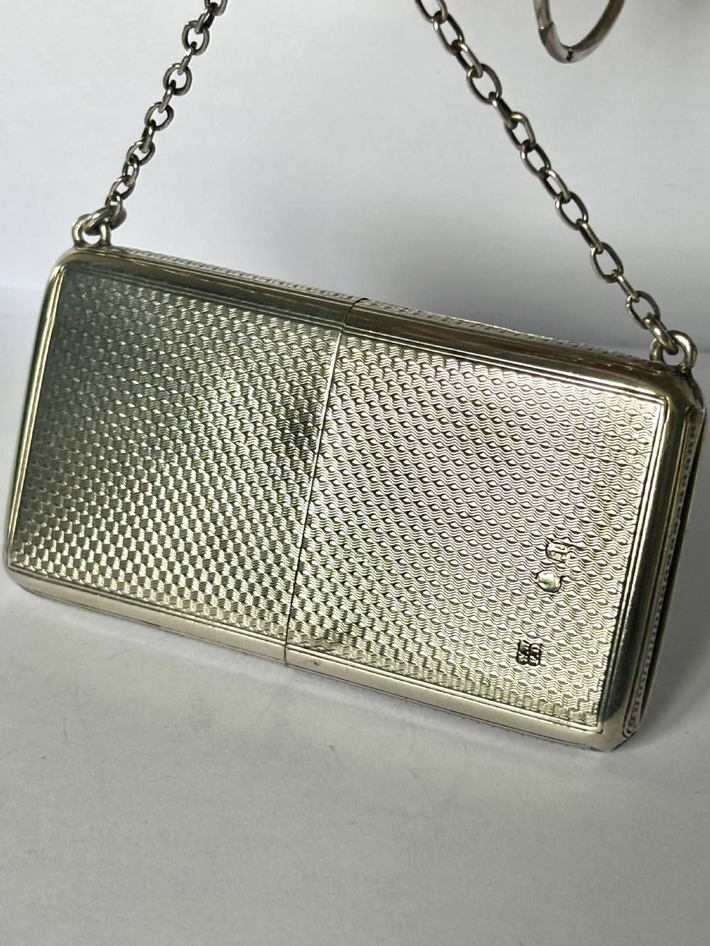 A Victorian sterling silver purse with engine-turned geometric engraving, shown open with a blue silk concertina lining beside a detachable silver case. View XIII