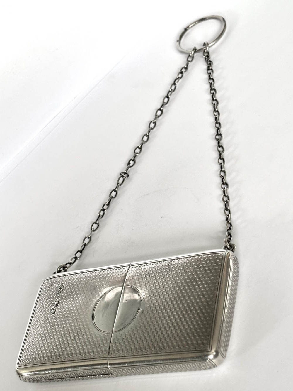 A Victorian sterling silver purse with engine-turned geometric engraving, shown open with a blue silk concertina lining beside a detachable silver case. View XIV