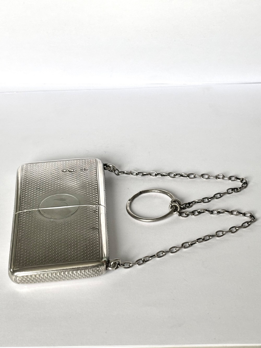 A Victorian sterling silver purse with engine-turned geometric engraving, shown open with a blue silk concertina lining beside a detachable silver case. View XV