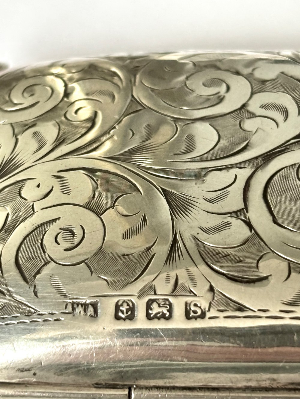 An engraved Art Deco sterling silver purse featuring a fine chain handle, detailed floral scrollwork, and a central polished oval cartouche. View IV