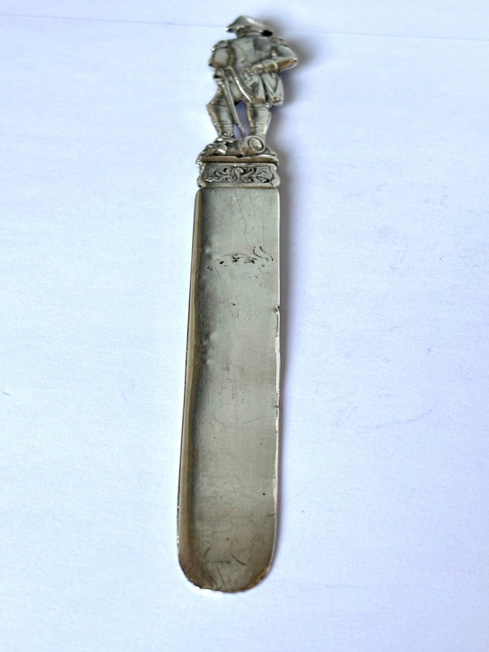 An Edwardian sterling silver letter opener featuring a cast figure of Napoleon on the handle and an engraved laurel wreath on the blade. View II