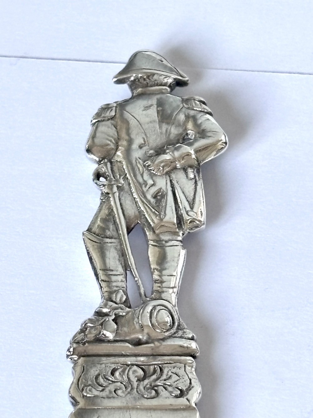 An Edwardian sterling silver letter opener featuring a cast figure of Napoleon on the handle and an engraved laurel wreath on the blade. View VI
