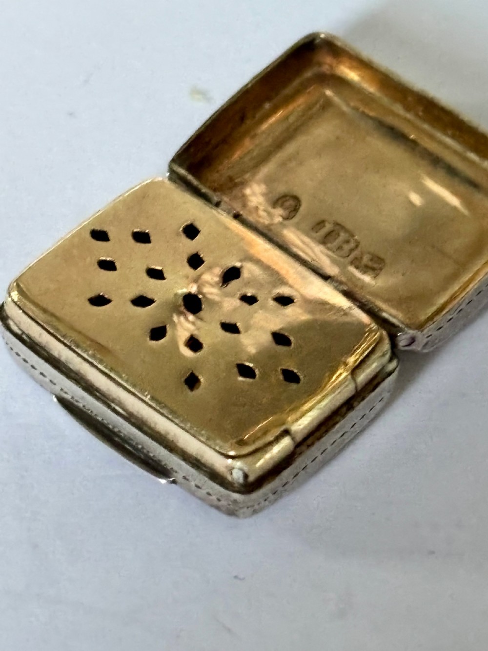 A rectangular George IV sterling silver vinaigrette with engine-turned geometric engraving and a blank central cartouche. View VI