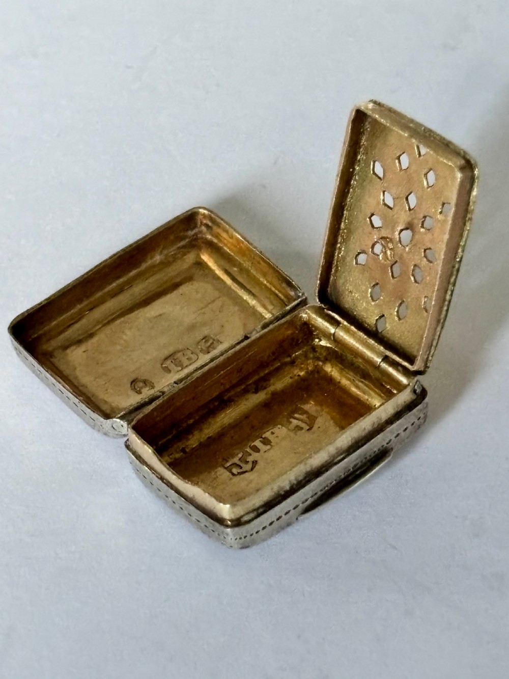 A rectangular George IV sterling silver vinaigrette with engine-turned geometric engraving and a blank central cartouche. View VII