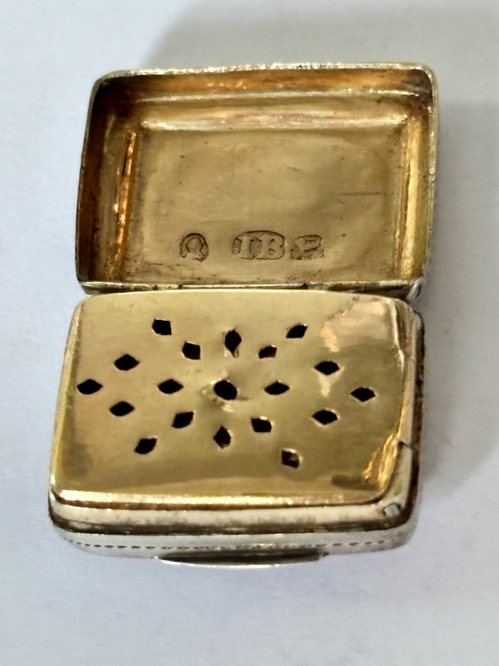 A rectangular George IV sterling silver vinaigrette with engine-turned geometric engraving and a blank central cartouche. View VIII