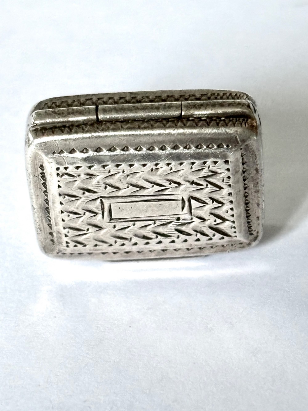 A rectangular George IV sterling silver vinaigrette with engine-turned geometric engraving and a blank central cartouche. View XI