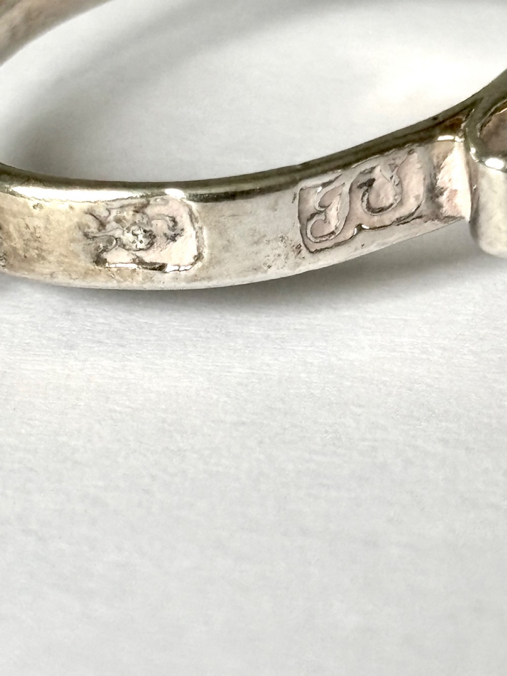 A pair of Georgian sterling silver sugar nips featuring scissor-action finger loops, scroll arms, and shell-shaped grips. View IV