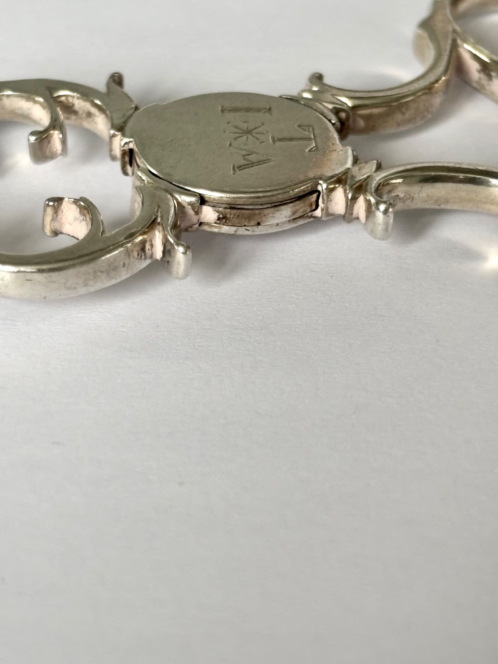 A pair of Georgian sterling silver sugar nips featuring scissor-action finger loops, scroll arms, and shell-shaped grips. View V