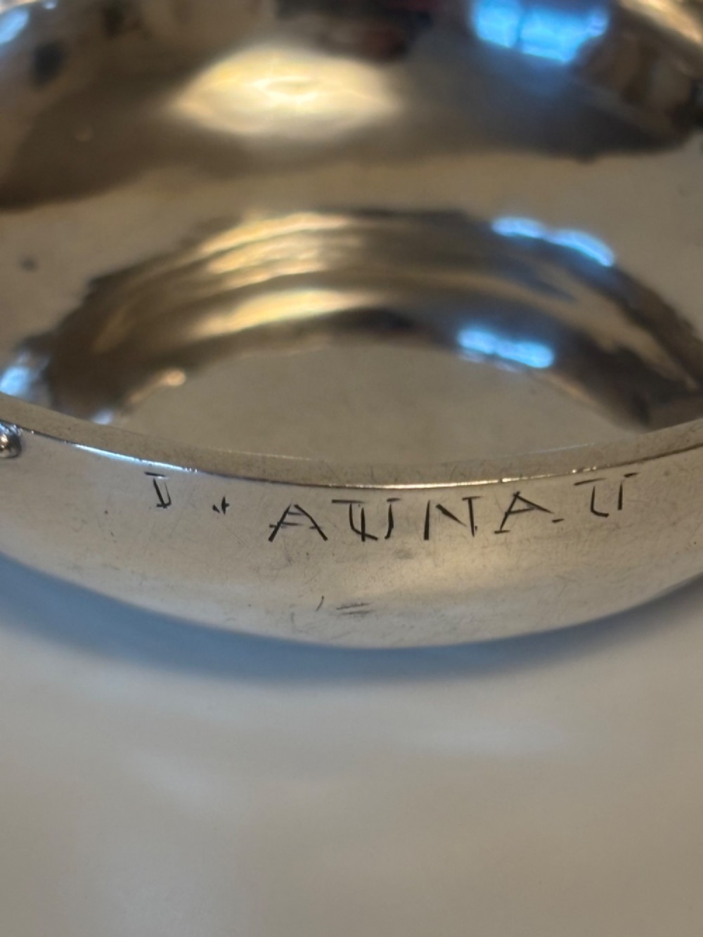 A shallow 19th-century French silver wine taster featuring a loop handle and engraved lettering on the outer rim. View III