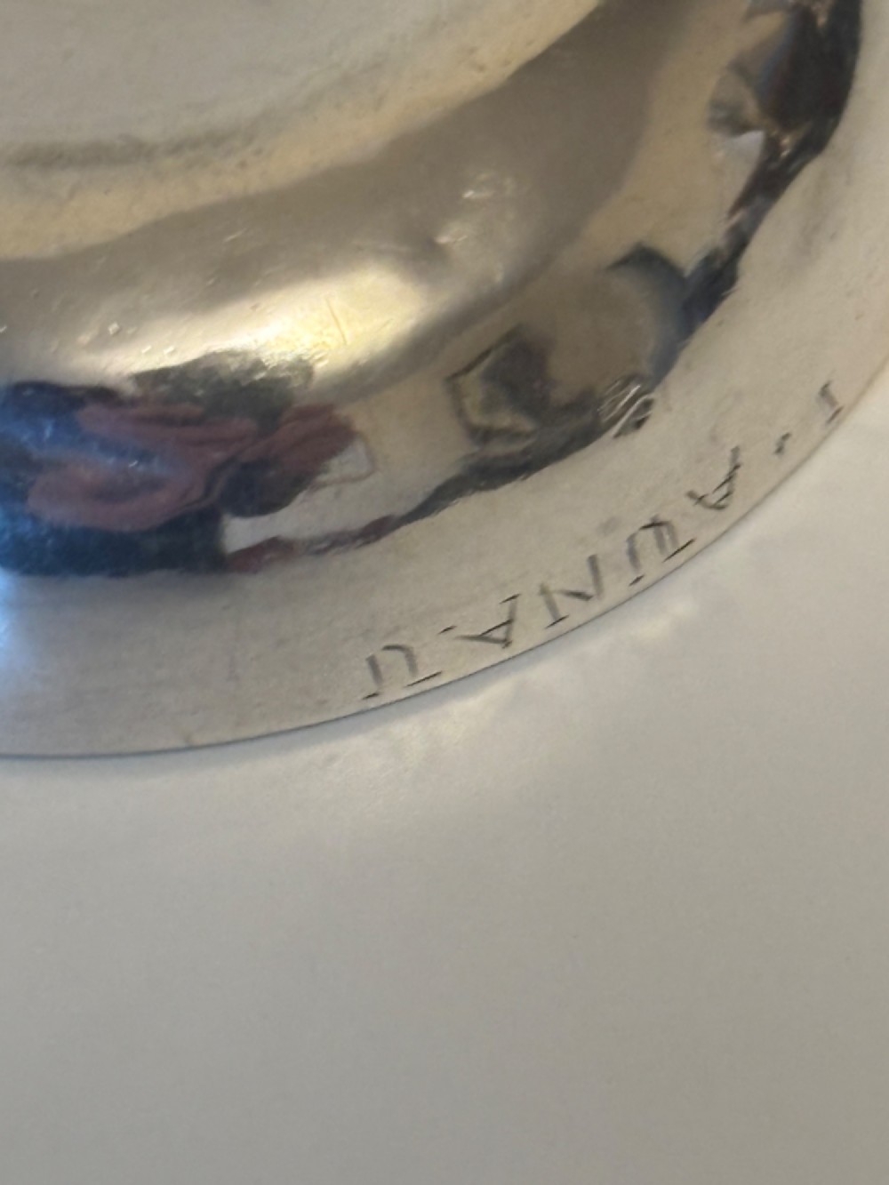 A shallow 19th-century French silver wine taster featuring a loop handle and engraved lettering on the outer rim. View VII
