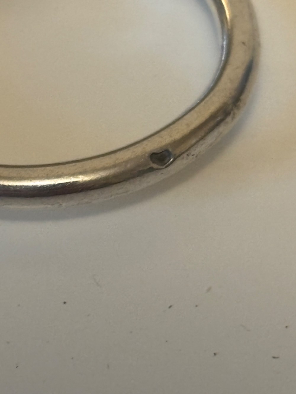 A shallow 19th-century French silver wine taster featuring a loop handle and engraved lettering on the outer rim. View XI