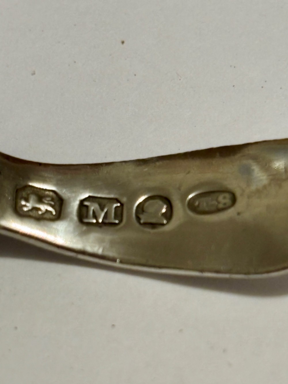 A George III sterling silver caddy spoon featuring a rounded bowl and a plain, short handle. View III
