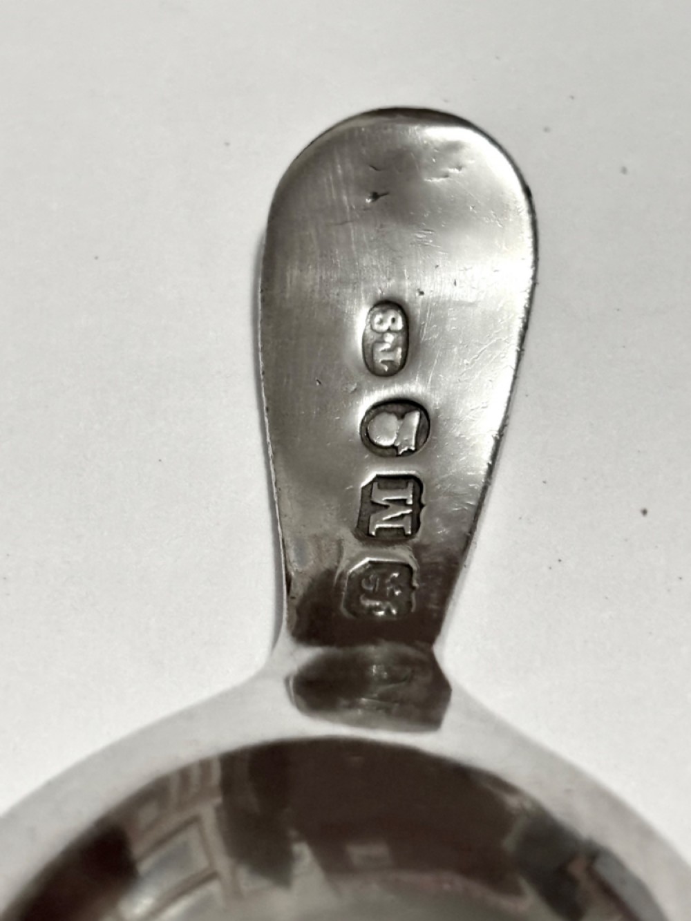 A George III sterling silver caddy spoon featuring a rounded bowl and a plain, short handle. View V