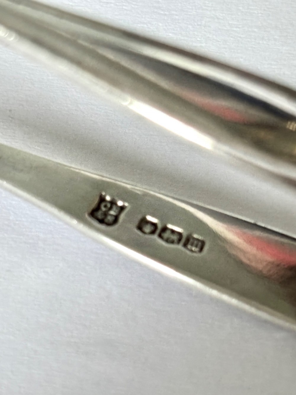 A pair of hallmarked sterling silver sugar nips featuring curved arms and claw-shaped grips resting on a light surface. View VII