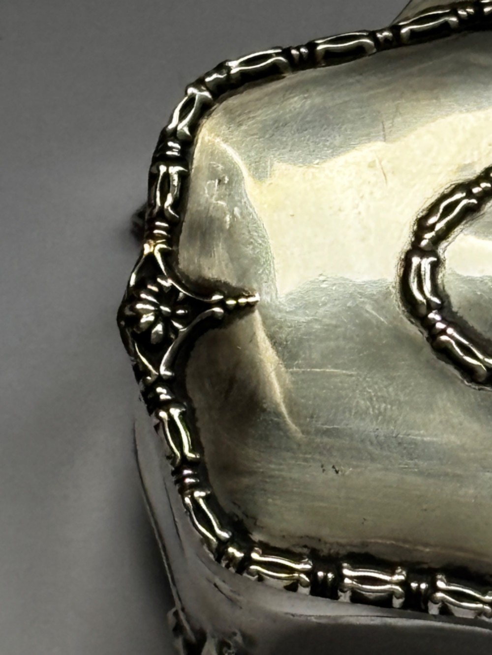 An open George V sterling silver trinket box featuring green velvet lining, gilt lid interior, and cabriole feet. View IX