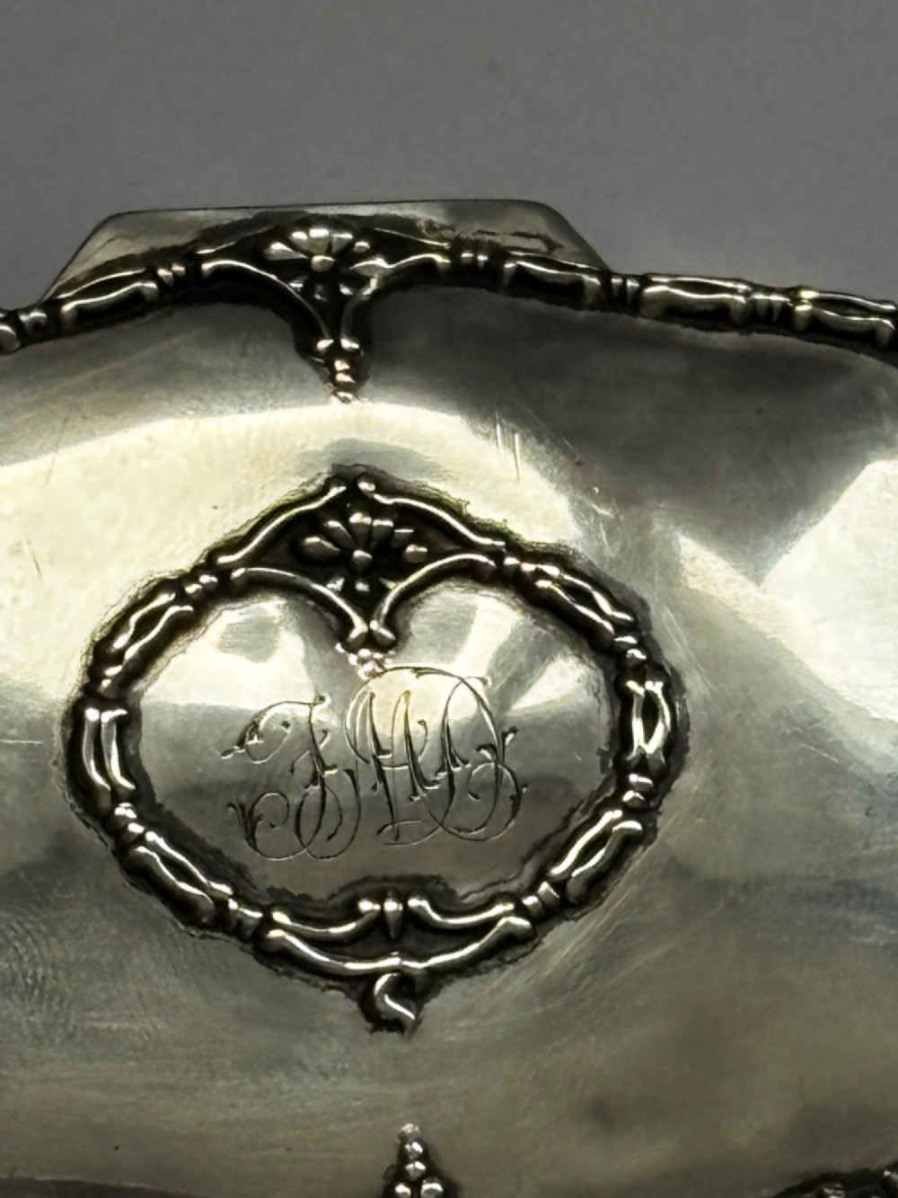 An open George V sterling silver trinket box featuring green velvet lining, gilt lid interior, and cabriole feet. View X