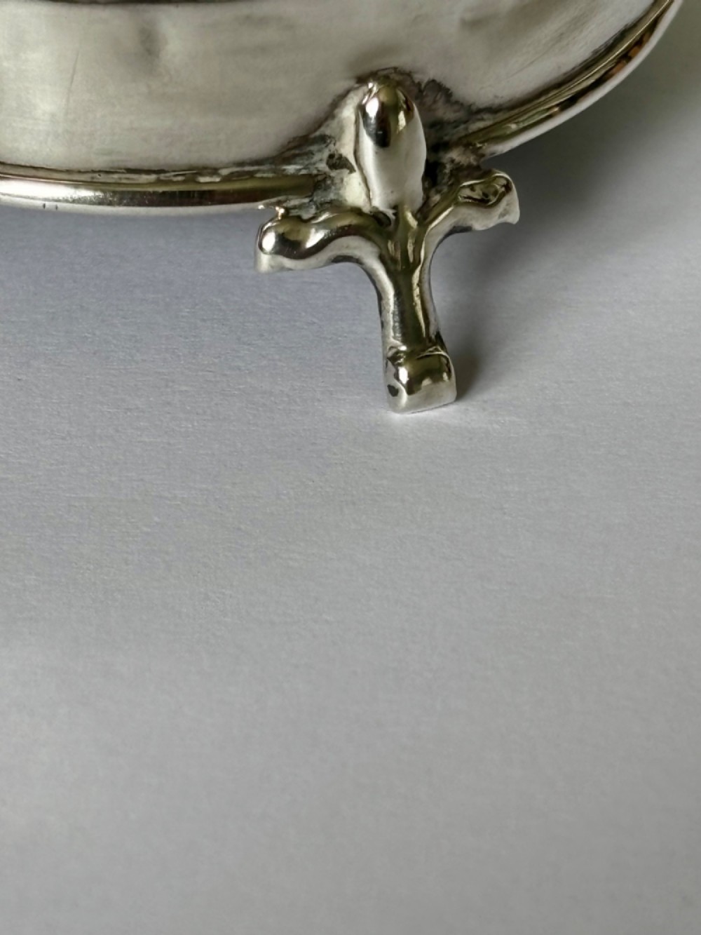 A circular George V sterling silver trinket box featuring engine-turned lid decoration, an engraved central cartouche, and four short pad feet. View VIII