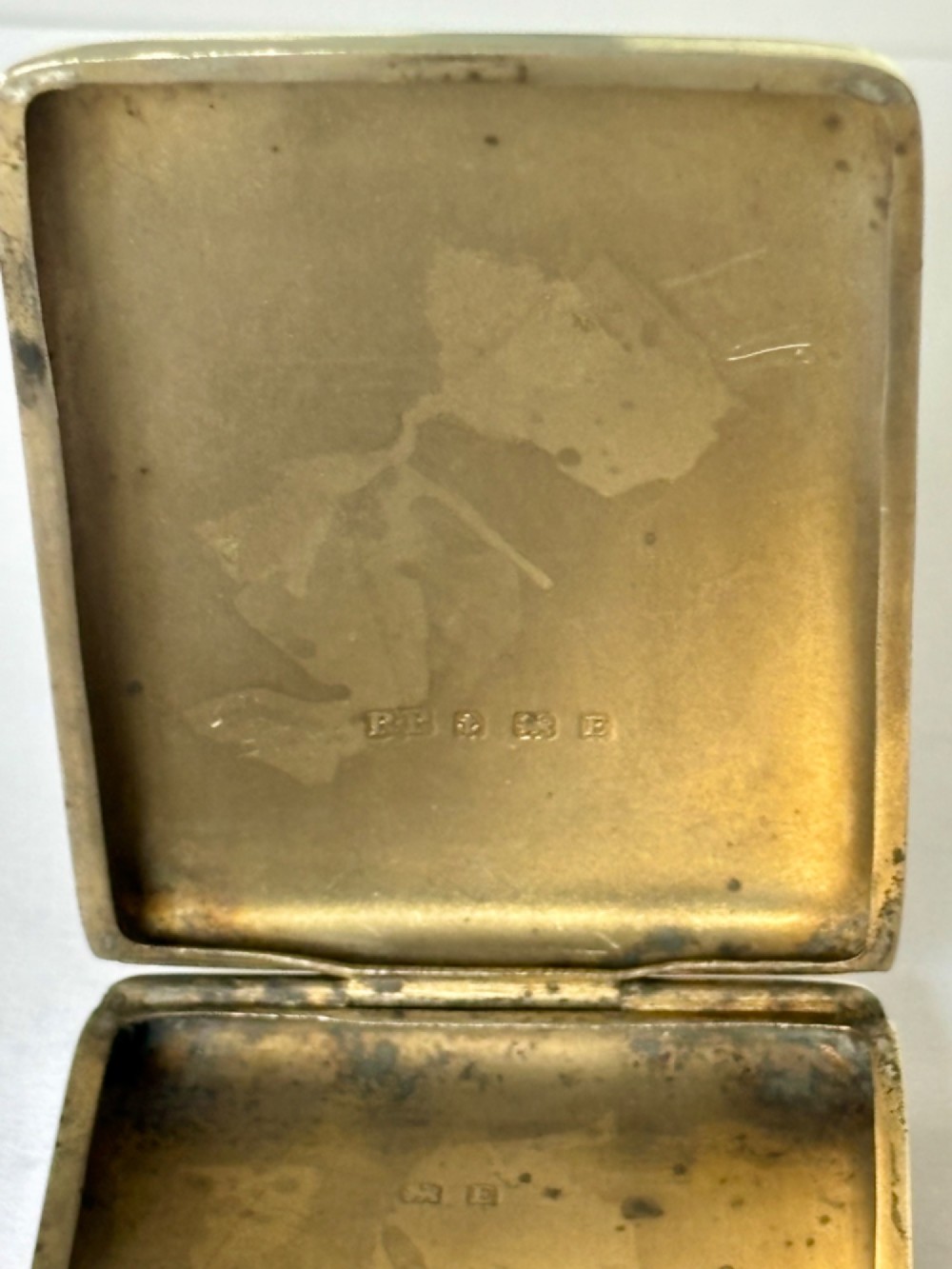 Rectangular sterling silver matchbook case featuring engine-turned geometric linear pattern and a central monogrammed cartouche. View VIII