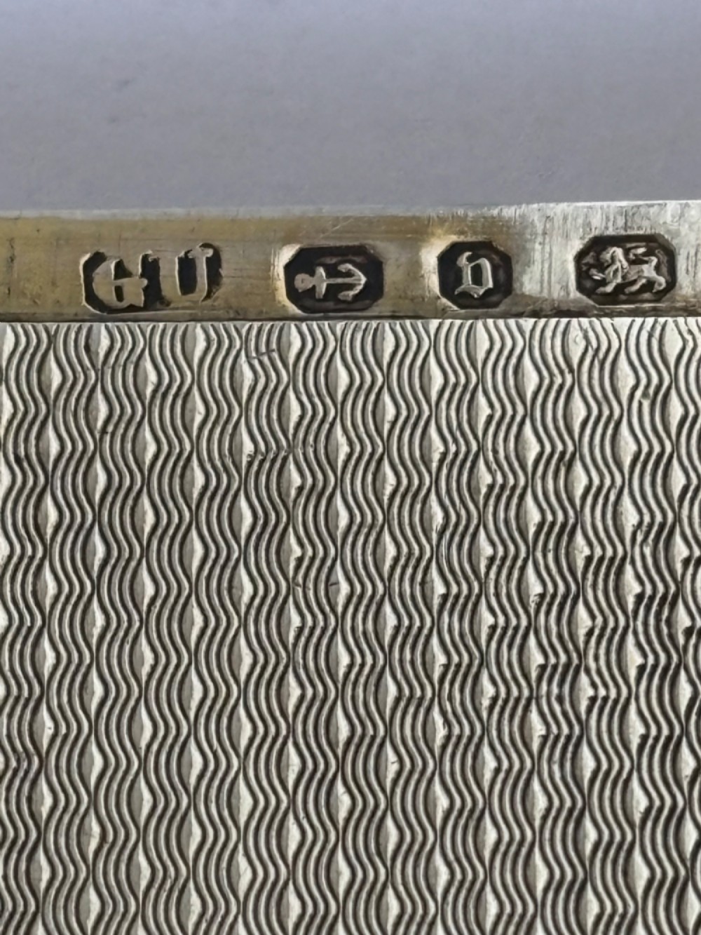 An antique Victorian sterling silver calling card case featuring shaped wavy edges, an engine-turned pattern, and an oval central cartouche. View IX