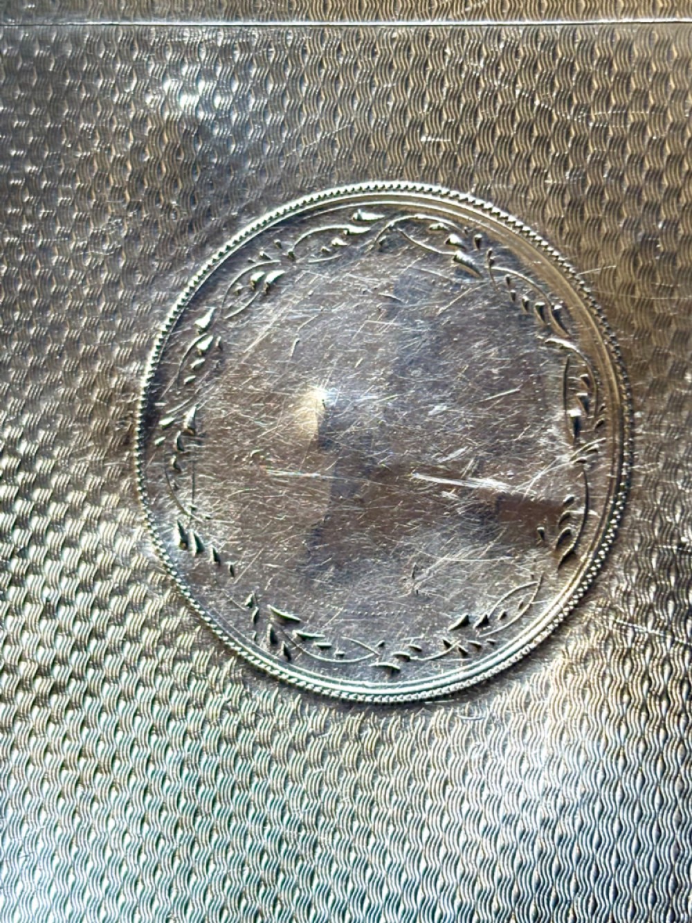An antique Victorian sterling silver calling card case featuring shaped wavy edges, an engine-turned pattern, and an oval central cartouche. View XI