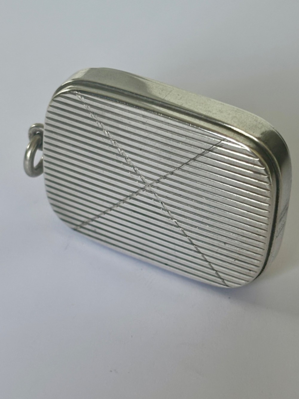 A small rectangular Victorian silver vesta case featuring horizontal reeded engine-turned decoration and an attached side suspension ring. View III