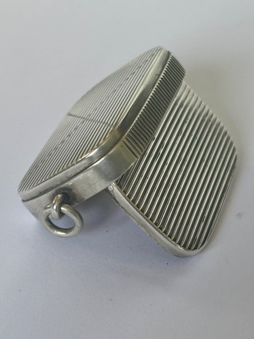 A small rectangular Victorian silver vesta case featuring horizontal reeded engine-turned decoration and an attached side suspension ring. View VI